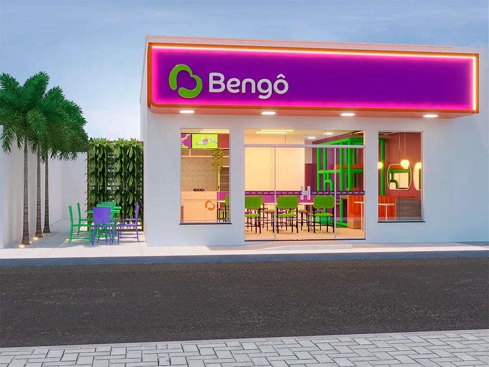 Fachada iluminada de uma loja franqueada Bengô Açaí com letreiro roxo e palmeiras
