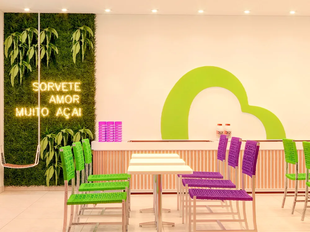 Interior de loja Bengô Açaí com jardim vertical e letreiro neon Sorvete Amor Muito Açaí